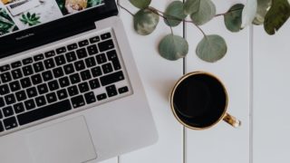 テーブルにあるコーヒーとPC