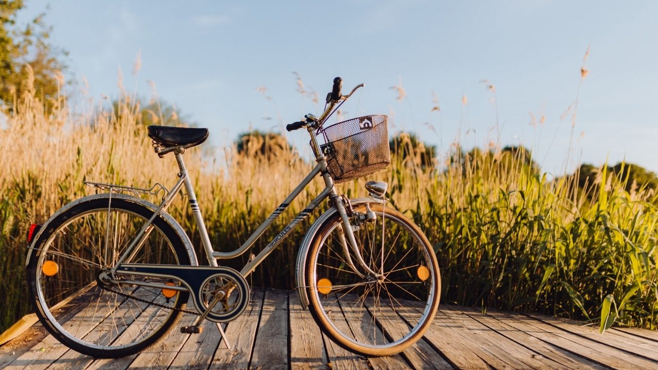 Bicycle with basket on the pier in bright sunset light-min