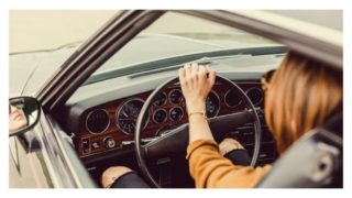 女性が車を運転している