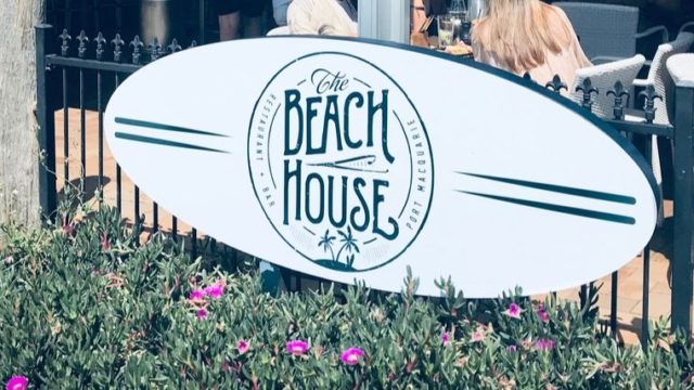 ビーチボードの看板にBeach houseと書かれている