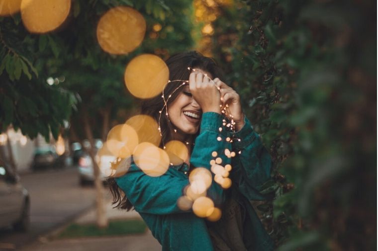 woman standing in front of green plants with light