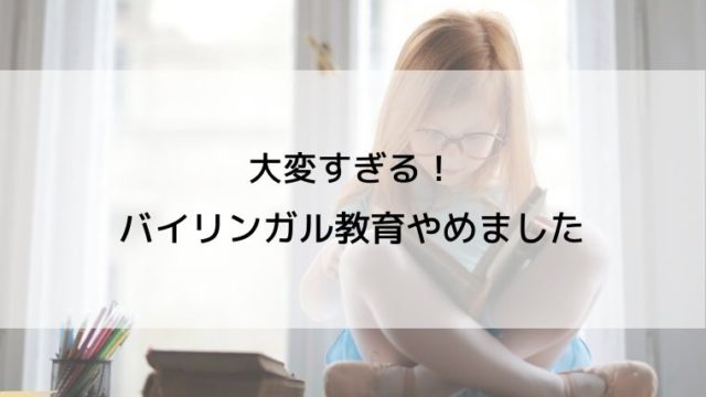 女の子があぐらをかいて本を読んでいる