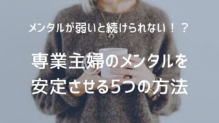 茶色いセーターを着た女性がマグカップを持って立っている